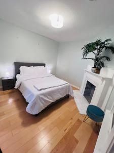 een witte slaapkamer met een bed en een open haard bij Cozy 1/1 near Piedmont Park ATL in Atlanta