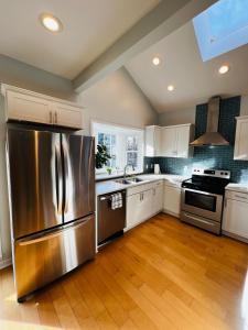 een keuken met een roestvrijstalen koelkast en witte kasten bij Cozy 1/1 near Piedmont Park ATL in Atlanta