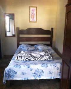 a bed with zebra pillows on top of it at Pousada Ciclo do Ouro in Ouro Preto