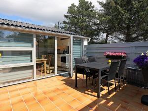 a patio with a table and chairs on a deck at Holiday home Vejers Strand XXI in Vejers Strand