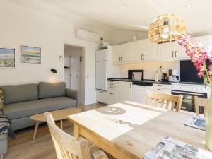 een keuken en een woonkamer met een tafel en een bank bij Holiday home Vejers Strand XXI in Vejers Strand