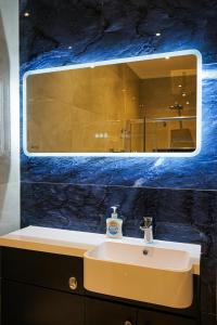 ein Bad mit einem Waschbecken und einem Spiegel in der Unterkunft Luxury 5 Star apartments, Parking, Garden, near Metro Stations 10-15mins to London in London