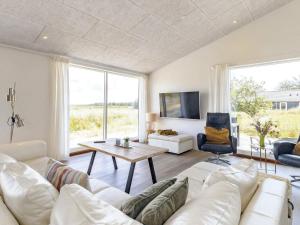 a living room with a white couch and a table at Holiday home Oksbøl LXXXIV in Oksbøl