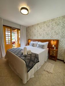 een slaapkamer met een groot wit bed in een kamer bij Pousada Rubi in Abraão