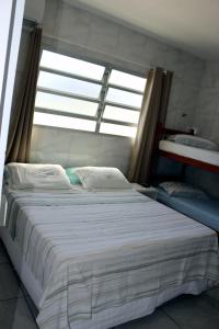 a large bed in a room with a window at Pousada Decarli Executiva Aeroporto Florianópolis in Florianópolis