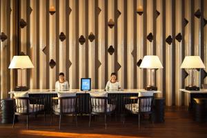 zwei Personen sitzen an einem Tisch mit einem Laptop in der Unterkunft Hua Hin Marriott Resort and Spa in Hua Hin