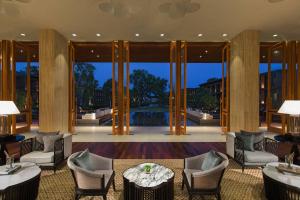 una hall con sedie, tavoli e grandi porte in vetro di Hua Hin Marriott Resort and Spa a Hua Hin