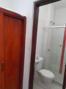 a bathroom with a toilet and a glass shower at Hotel Isla Capri in Mompós