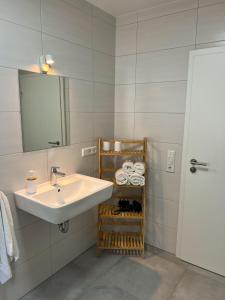 a bathroom with a sink and a mirror and towels at Home Inn Apartments - 101 in Bielefeld