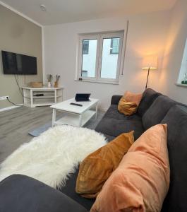 ein Wohnzimmer mit einem Sofa und einem Tisch in der Unterkunft Home Inn Apartments - 101 in Bielefeld