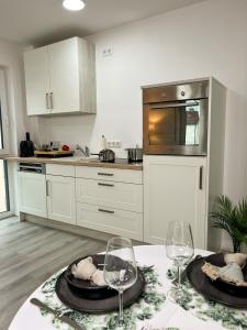 una cocina con una mesa con dos copas de vino. en Home Inn Apartments - 101 en Bielefeld