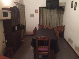 a dining room with a table and chairs and a television at La Tardecita - Valle del Sol in Potrerillos