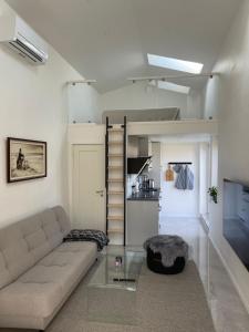 a living room with a couch and a stair case at Modern guesthouse with loft in Malmö