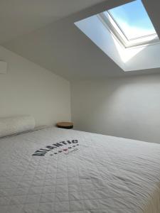 a white bedroom with a bed with a skylight at Modern guesthouse with loft in Malmö