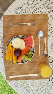 - un plateau en bois avec une assiette de fruits et légumes dans l'établissement Pousada Rubi, à Abraão