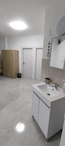 a white bathroom with a sink and a mirror at דירת נופש in Rekhasim