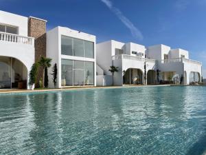 a swimming pool in front of a house at Villa La Falaise in Oualidia