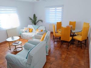 a living room with a couch and a table and chairs at El Mirador de playa LAPAMAN - BUEU in Marín