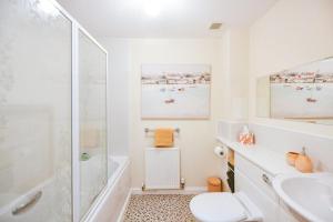 a white bathroom with a shower and a sink at Fabulous Flat in Stirling