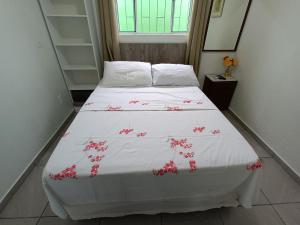 a bedroom with a bed with pink flowers on it at Pousada Decarli Executiva Aeroporto Florianópolis in Florianópolis