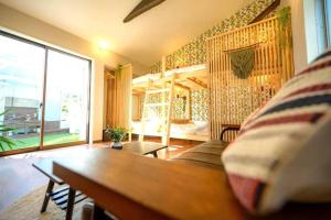 sala de estar con sofá y ventana grande en 日向サーフキャンプ203, en Hyuga