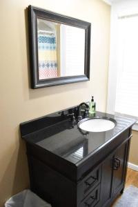 baño con lavabo negro y espejo en The House Hotels - New Crestview, en Columbus