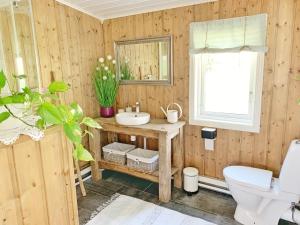 a wooden bathroom with a sink and a mirror at The Buar Cabin in Strömstad