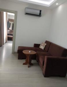 sala de estar con sofá marrón y mesa en Plaj resort dorra en Buyukcekmece