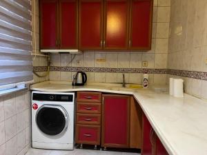 - une cuisine avec des placards rouges et un lave-linge dans l'établissement Sultanahmet Corner Apart, à Istanbul