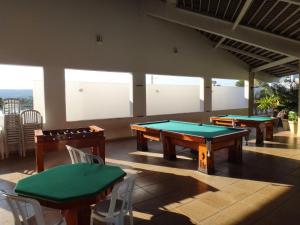 a room with two ping pong tables and chairs at Apartamento Enseada Náutico Caldas Novas - GO in Caldas Novas