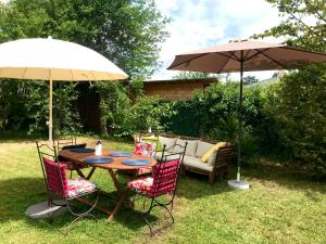 a table and chairs with an umbrella and a couch at Superbe studio privé in Thionville