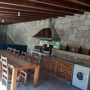 a kitchen with a wooden table and a stove at Moinho das Cavadas in Ponte da Barca +43 photos
