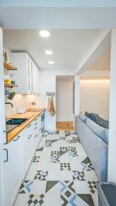 a kitchen with a couch and a tile floor at Apartejo River Tagus View in Póvoa de Santa Iria