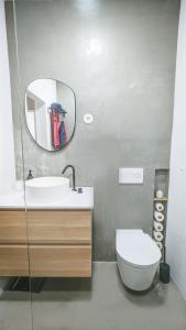 a bathroom with a sink and a toilet and a mirror at Apartejo River Tagus View in Póvoa de Santa Iria