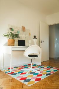 una oficina con una silla blanca y una alfombra colorida en Apartejo River Tagus View en Póvoa de Santa Iria