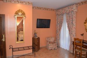 a room with a mirror and a tv on the wall at Hotel Don Javier in Ronda