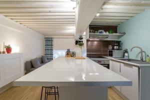 een grote witte keuken met een groot wit aanrecht bij Appartement cosy de caractère - Place Sathonay in Lyon