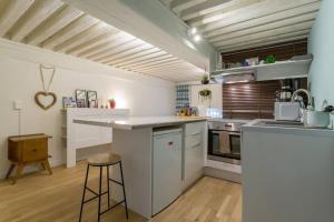 een keuken met witte kasten en een aanrecht bij Appartement cosy de caractère - Place Sathonay in Lyon