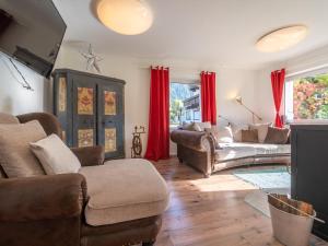 uma sala de estar com mobiliário de couro e cortinas vermelhas em Regenbogenhaus em Mayrhofen