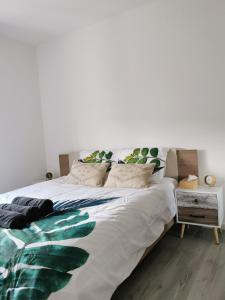 a bedroom with a large white bed with green leaves at AtHome - Appart-hotel with private parking in Esch-sur-Alzette