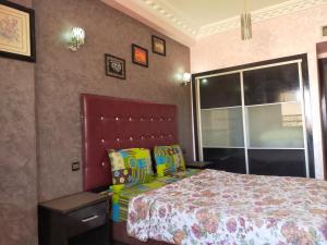een slaapkamer met een bed en een groot raam bij MCL Majorelle Appartement in Marrakesh