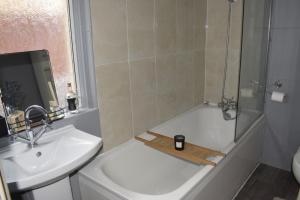 a bathroom with a shower and a sink and a bath tub at Entire 3 Bedroom Home With Garden In London in Edmonton