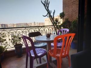 een tafel en stoelen op een balkon met uitzicht bij MCL Majorelle Appartement in Marrakesh