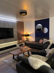 a living room with a couch and a table at Luxury Apartment near Munich Airport - Therme ED - Parking in Berglern