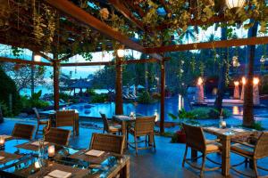 een restaurant met tafels en stoelen en een zwembad bij Sheraton Senggigi Beach Resort in Senggigi 