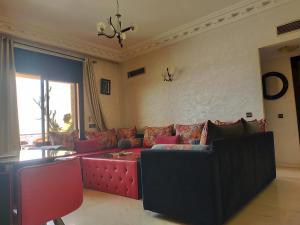 een woonkamer met een rode bank en een tafel bij MCL Majorelle Appartement in Marrakesh