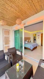 Suite privada frente al mar. في San Silvestre: غرفة معيشة مع سرير وطاولة وكراسي