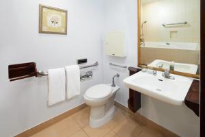 a bathroom with a white toilet and a sink at Sheraton Senggigi Beach Resort in Senggigi