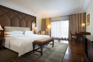a bedroom with a large bed and a large window at Sheraton Senggigi Beach Resort in Senggigi