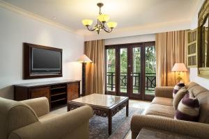a living room with a couch and a tv at Sheraton Senggigi Beach Resort in Senggigi